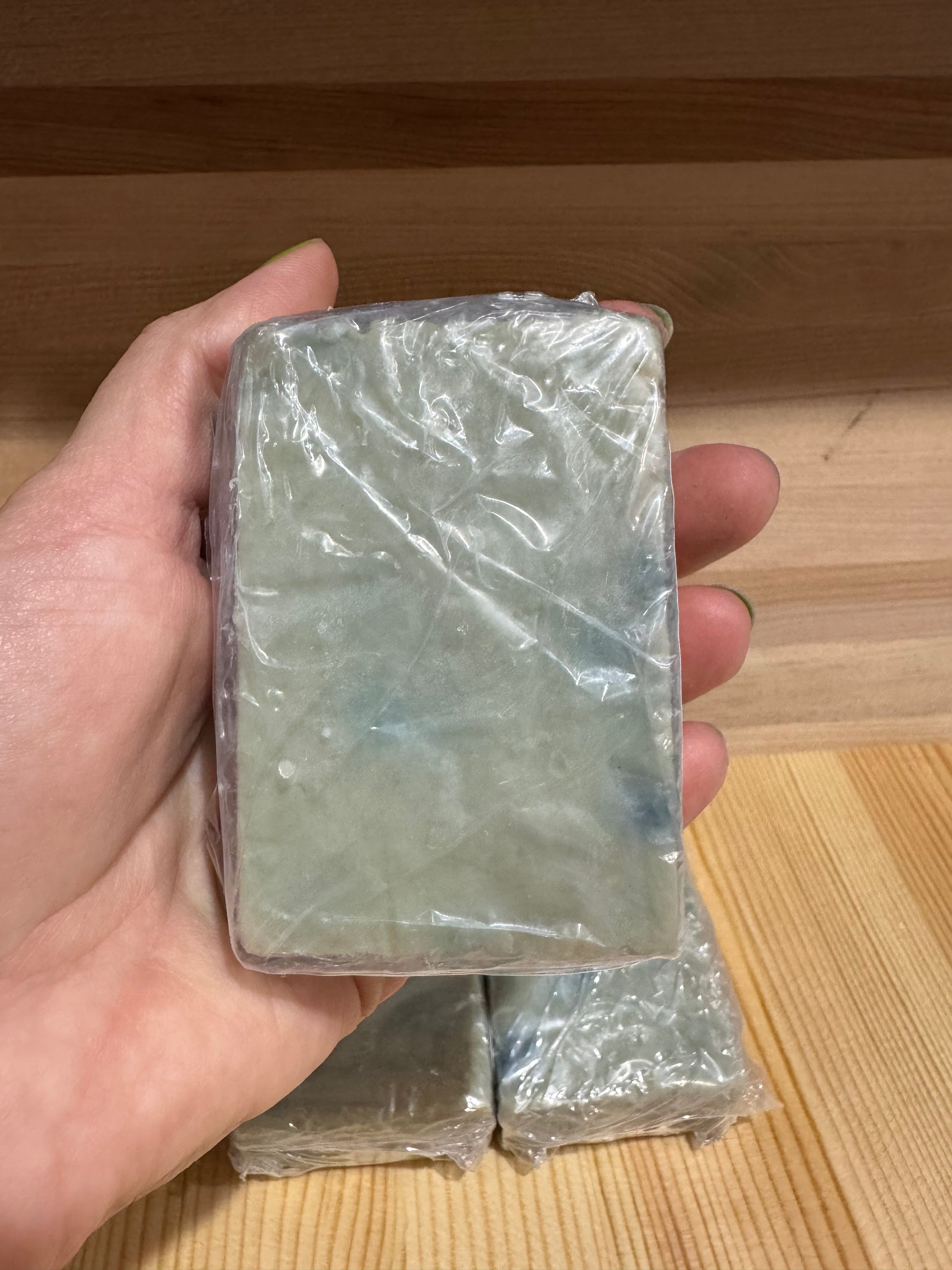 Texture detail of handmade natural soap with blue and green swirls.