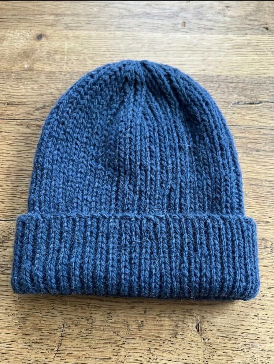 A photo of a hat knitted from the indigo hand-dyed and hand-spun wool yarn by No Kidding Farm and Vineyard