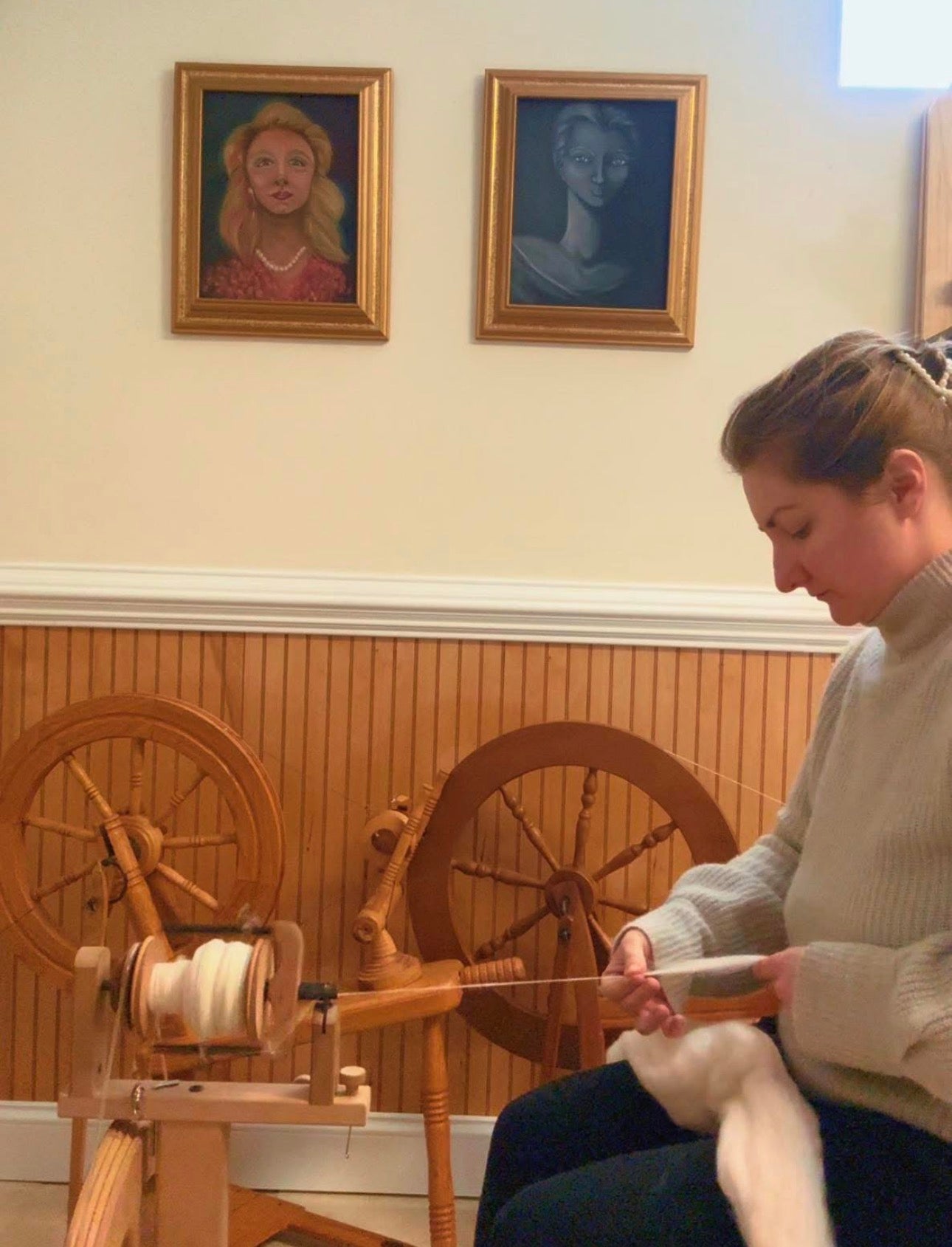 Picture of a woman hand-spinning Merino wool roving into yarn 